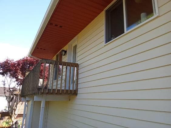 Newly painted siding and fascia in a light yellow color